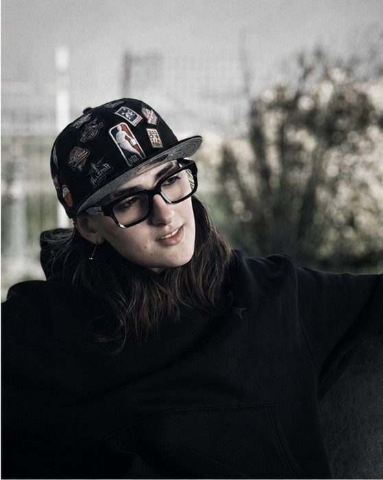 Nemesi con cappellino e occhiali, all'aperto